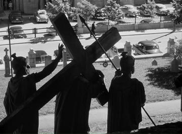 I Confess_Father Logan walks past the statue of Jesus and the cross